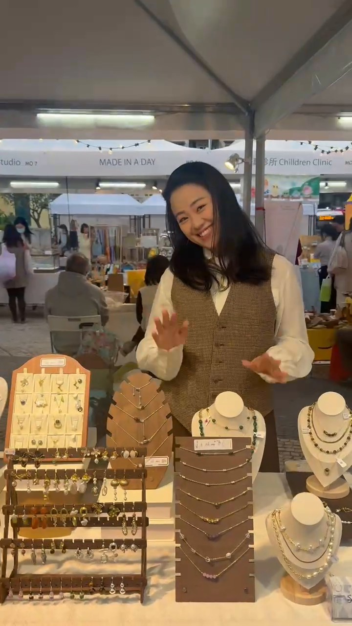 A person behind the illuminated Susan&Xin jewellery display at the Macao market.